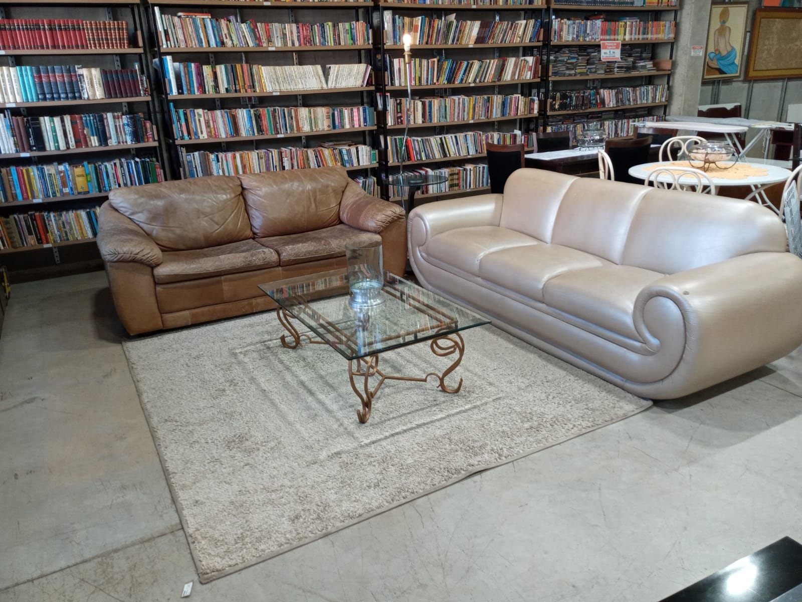 Sofás de couro, mesa de centro e estante de livros na loja